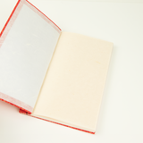 Open Hanji notebook with red binding on a white background
