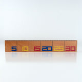 Wooden De Stilj ruler with colorful letters on a white background
