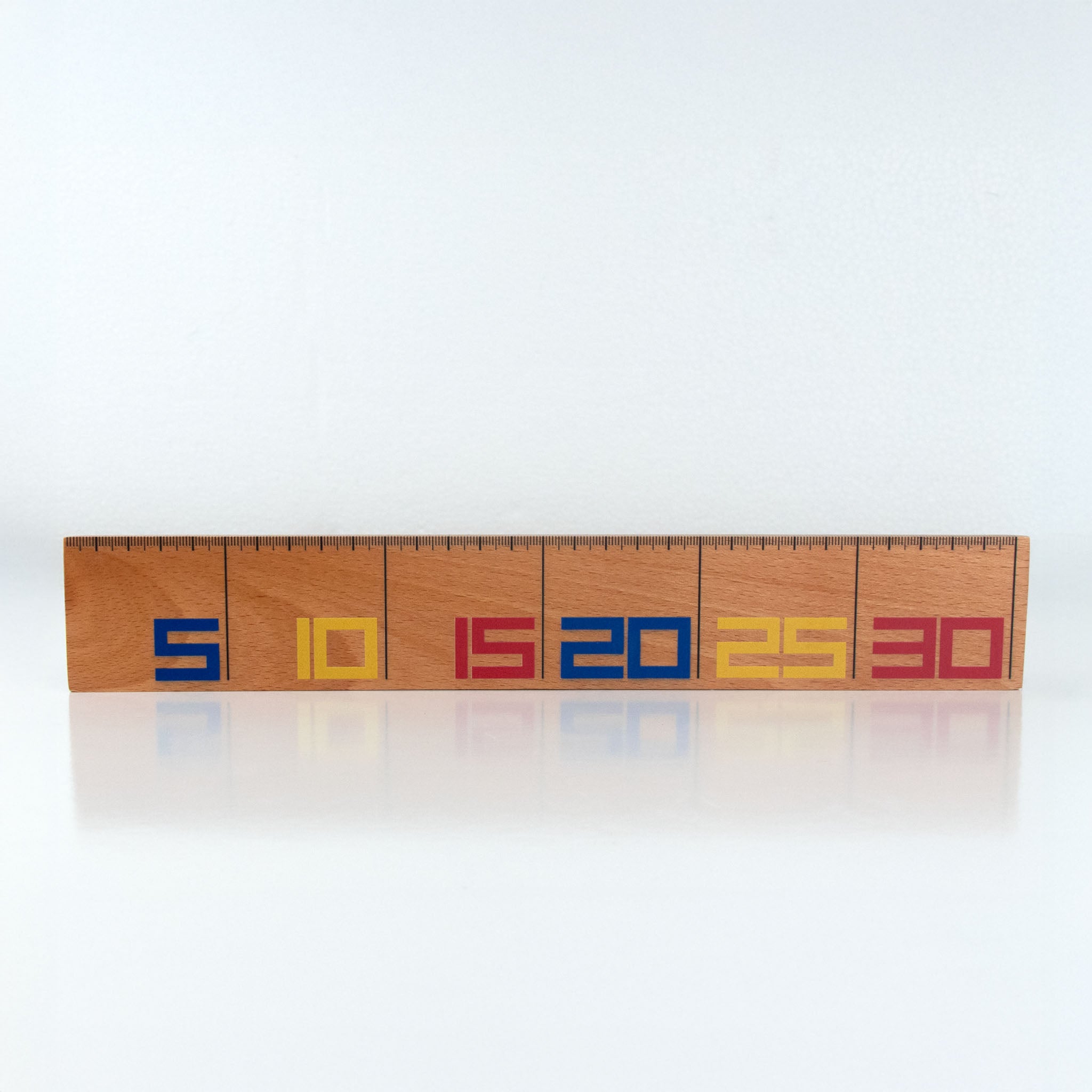 Wooden De Stilj ruler with colorful letters on a white background