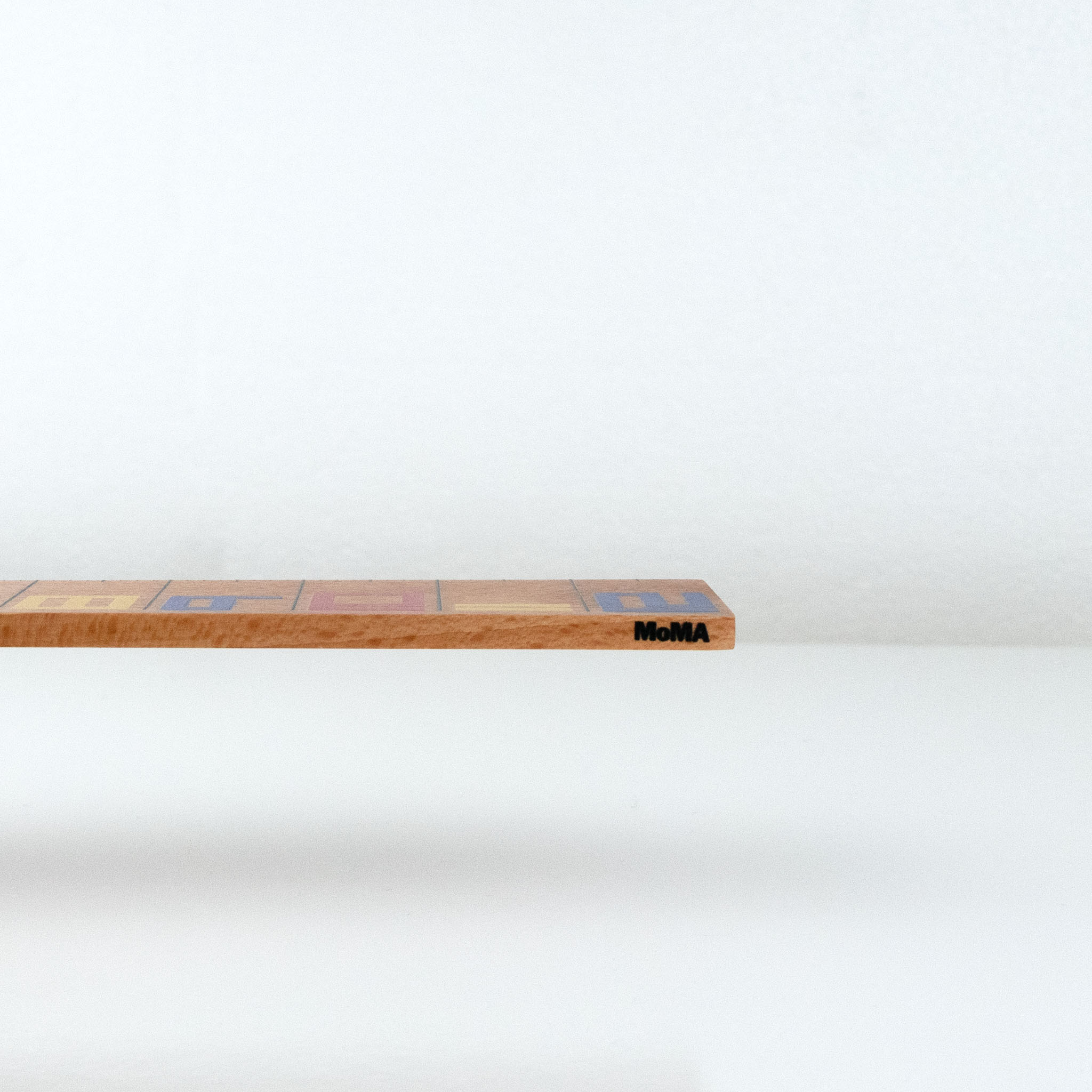 Wooden De Stilj ruler with MoMA logo on a white background