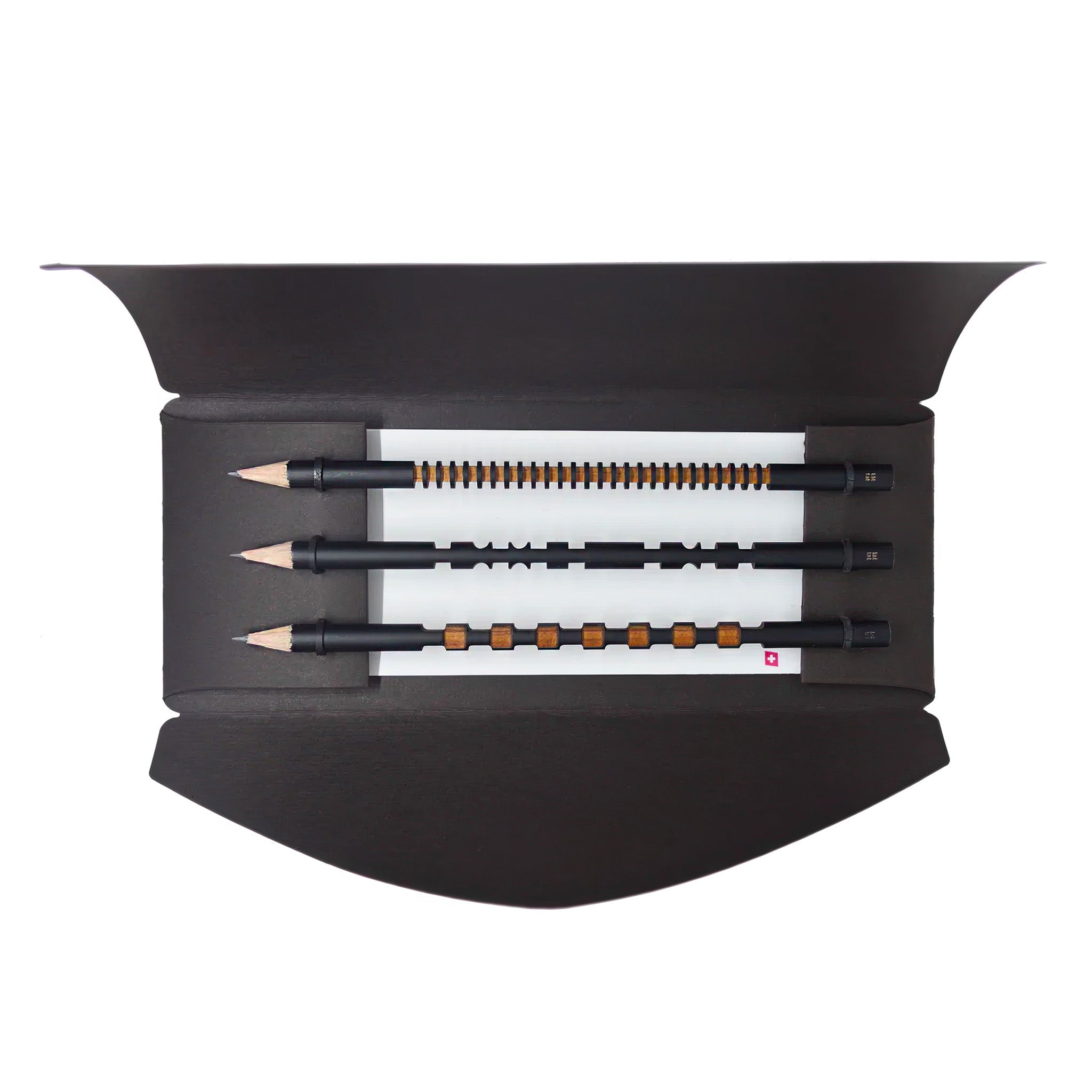 Set of black pencils with unique designs encased in a dark brown envelope