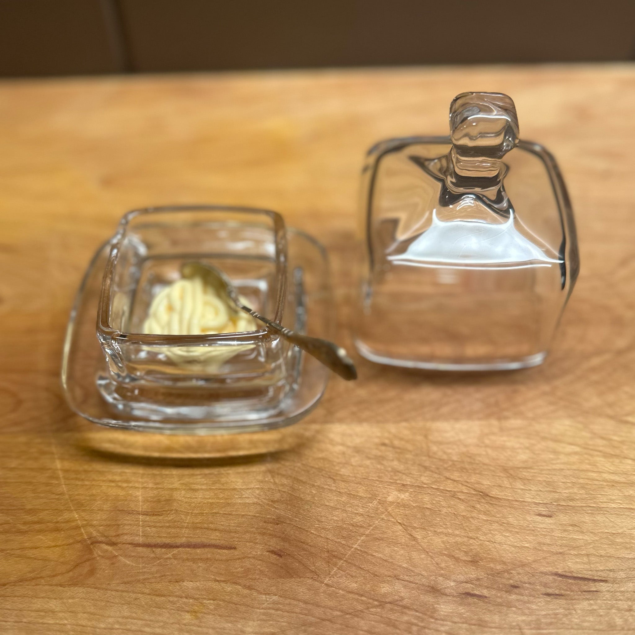 Image of Earth & Nest's Cloche square condiment glass container open on a wooden cutting board with mayonnaise.