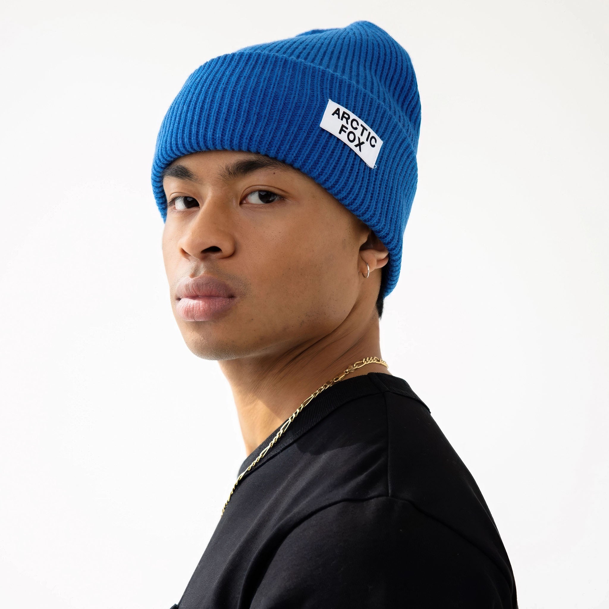 Model wearing a blue beanie with a brand logo Arctic Fox on a white background