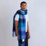 Man wearing a blue plaid scarf on a plain background