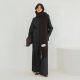 Model wearing a long dark brown scarf with a plain background