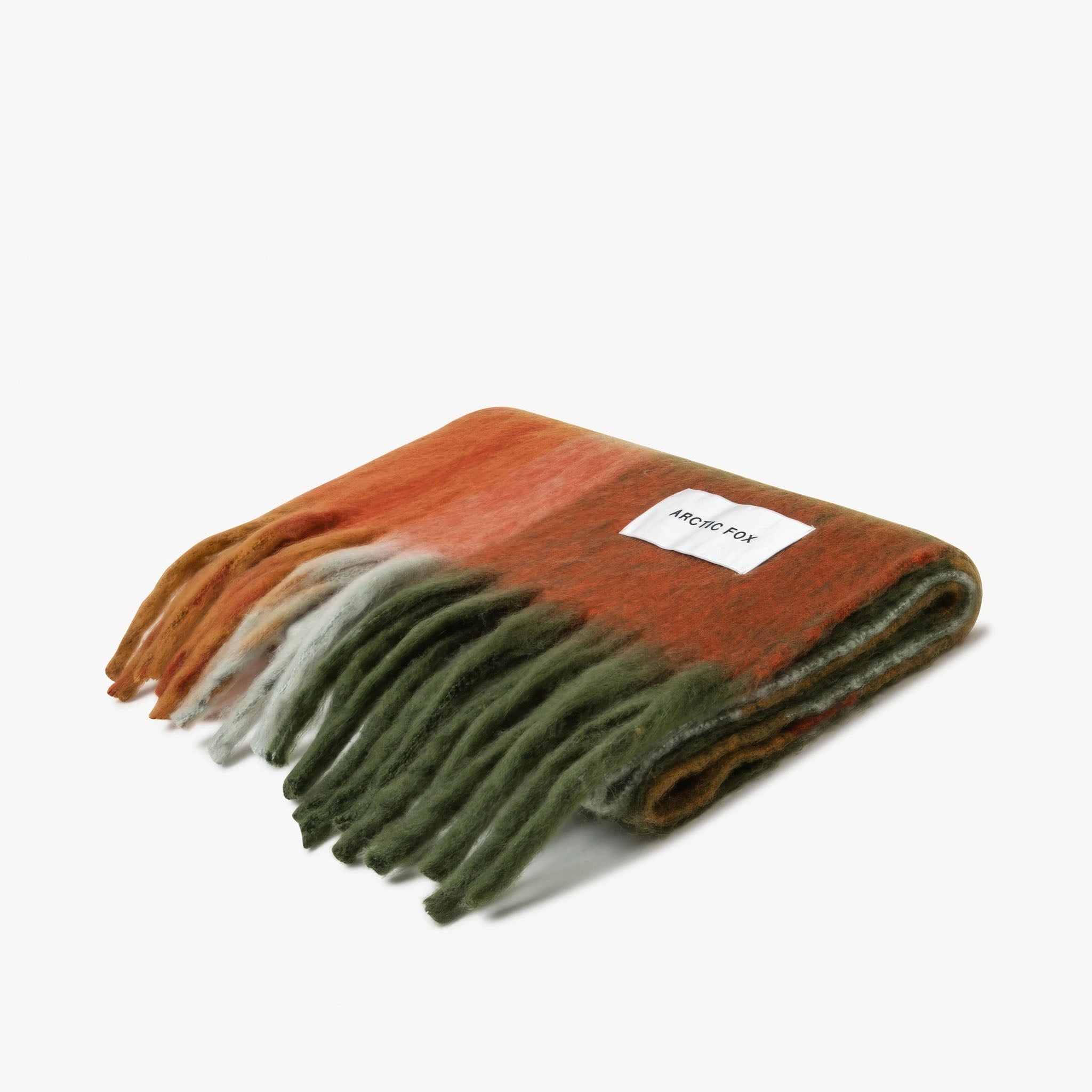 Folded multicolored blanket with a brand label Arctic Fox on a white background