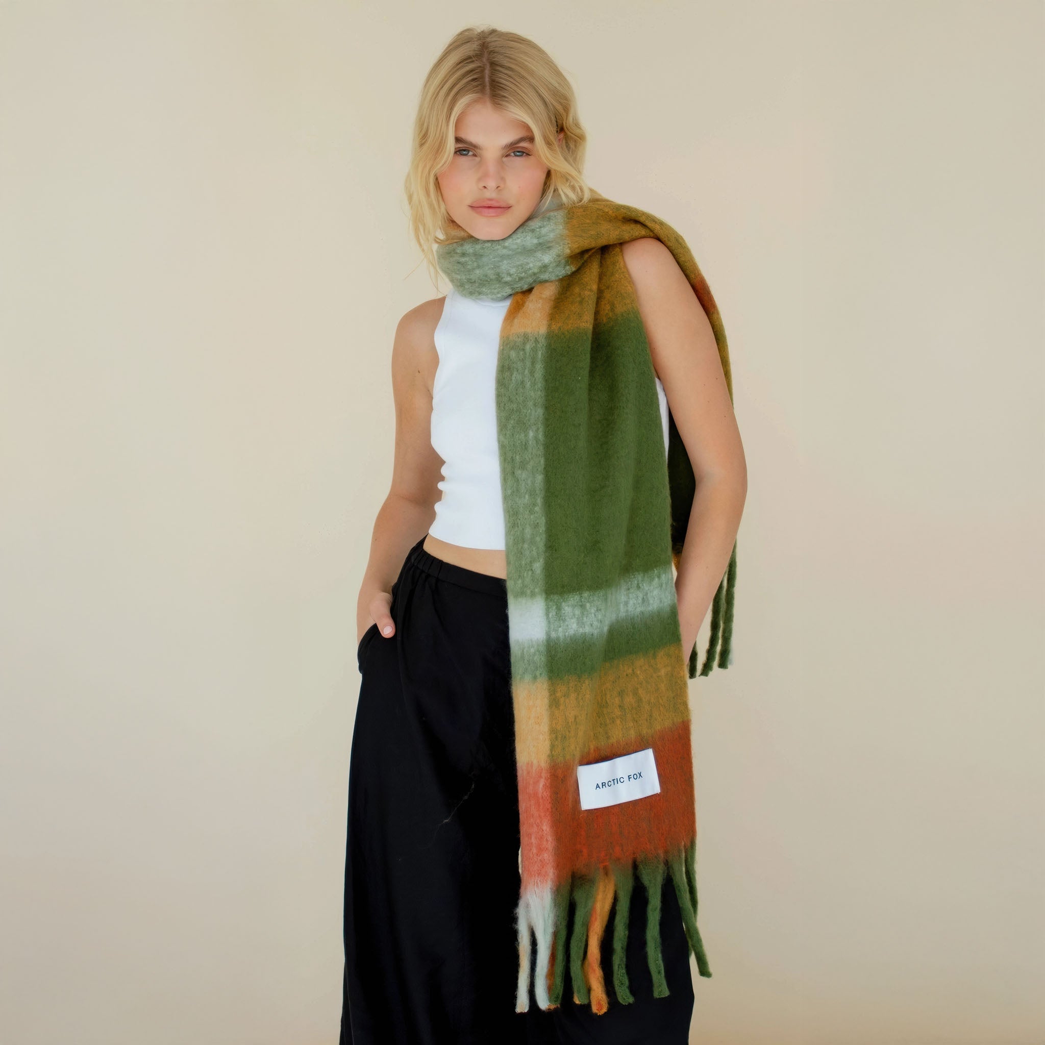 Model wearing a multicolor plaid scarf with a plain background