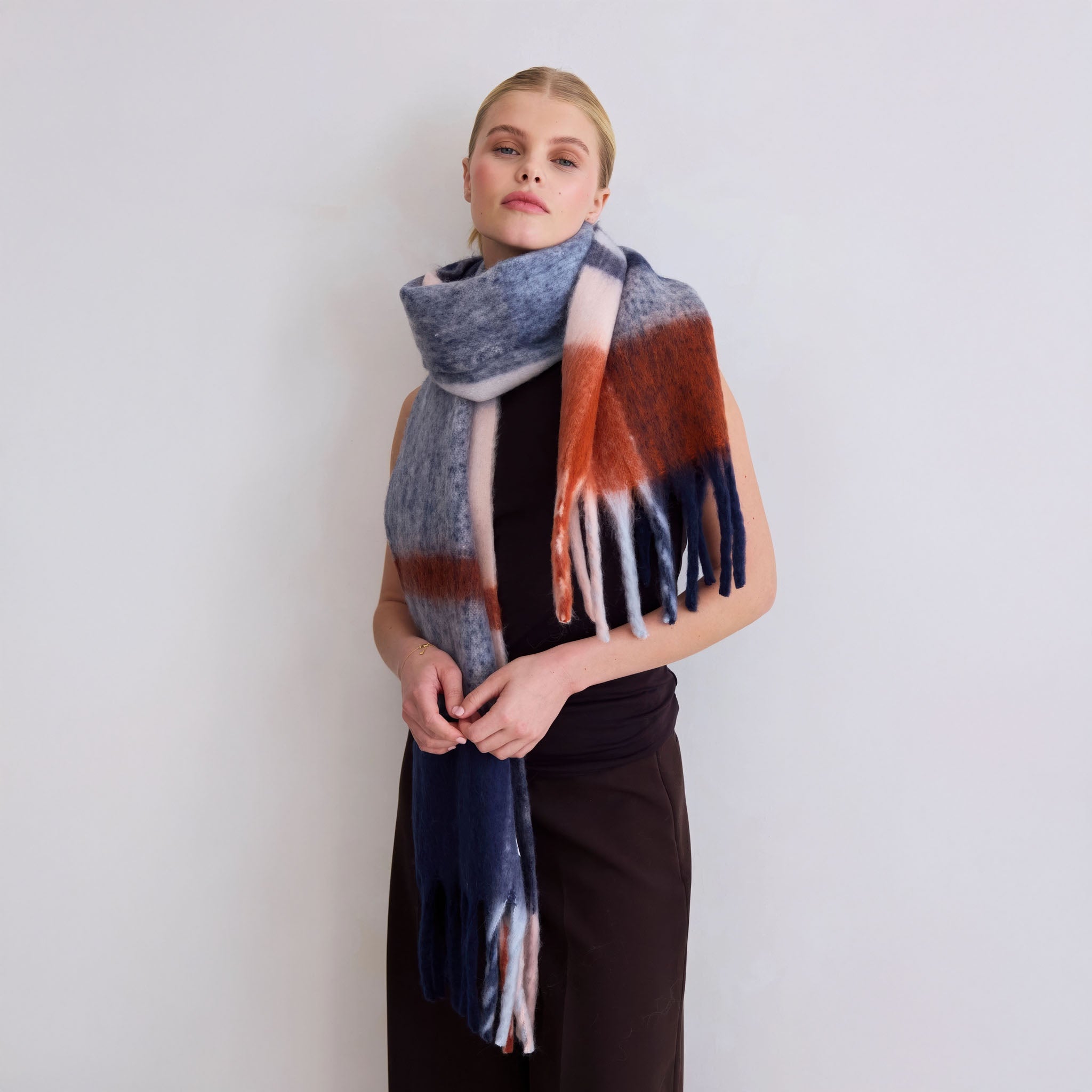 Model wearing the multicolor plaid scarf against a plain background