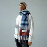 Model wearing the multicolor plaid scarf against a plain background