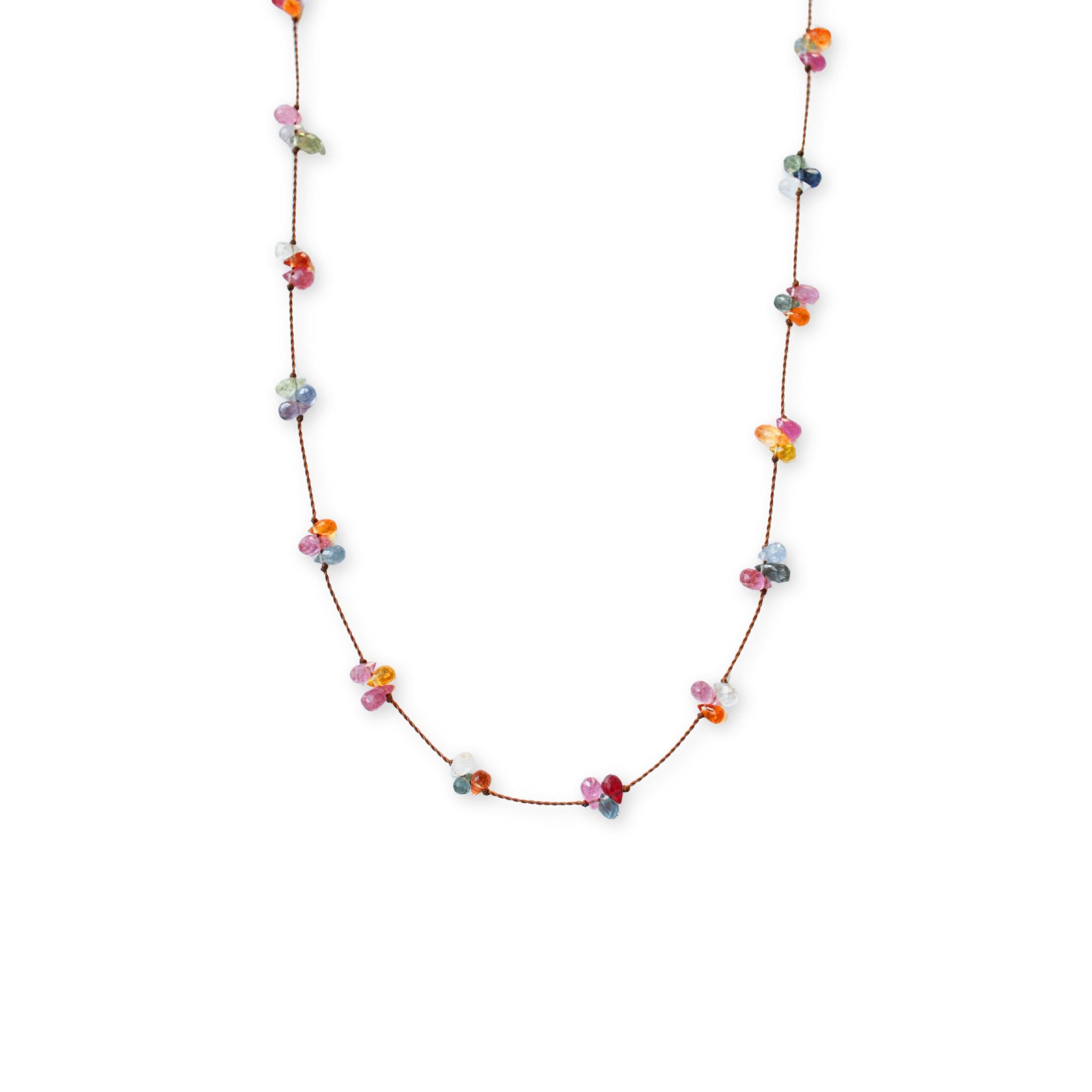 Close-up of the See Real Flowers Berry Necklace featuring clusters of colorful rainbow sapphire beads knotted along a fine brown nylon cord.