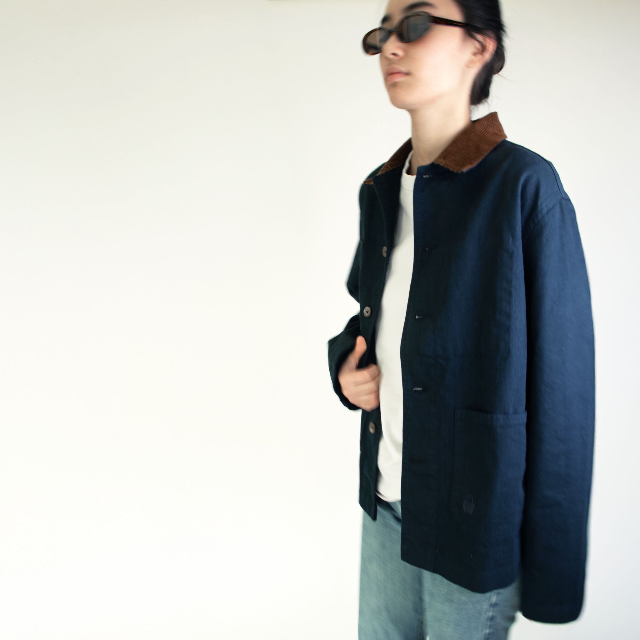 Model wearing the Nimes unisex chore blue jacket with a brown corduroy collar on a white background