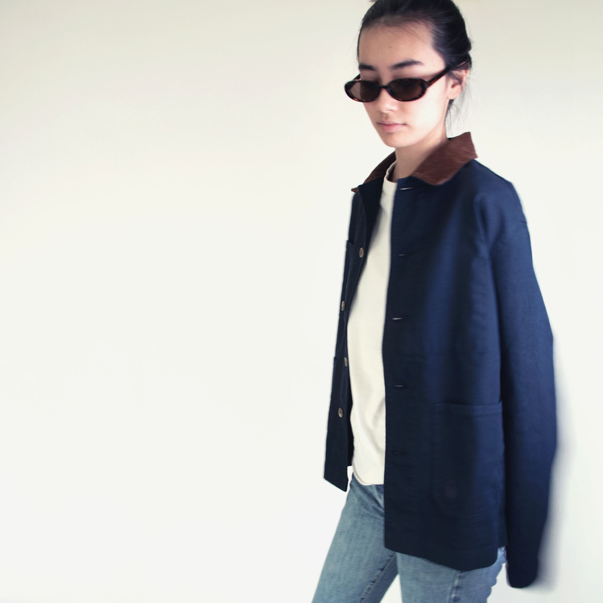 Model wearing the Nimes unisex chore blue jacket with a brown corduroy collar on a white background