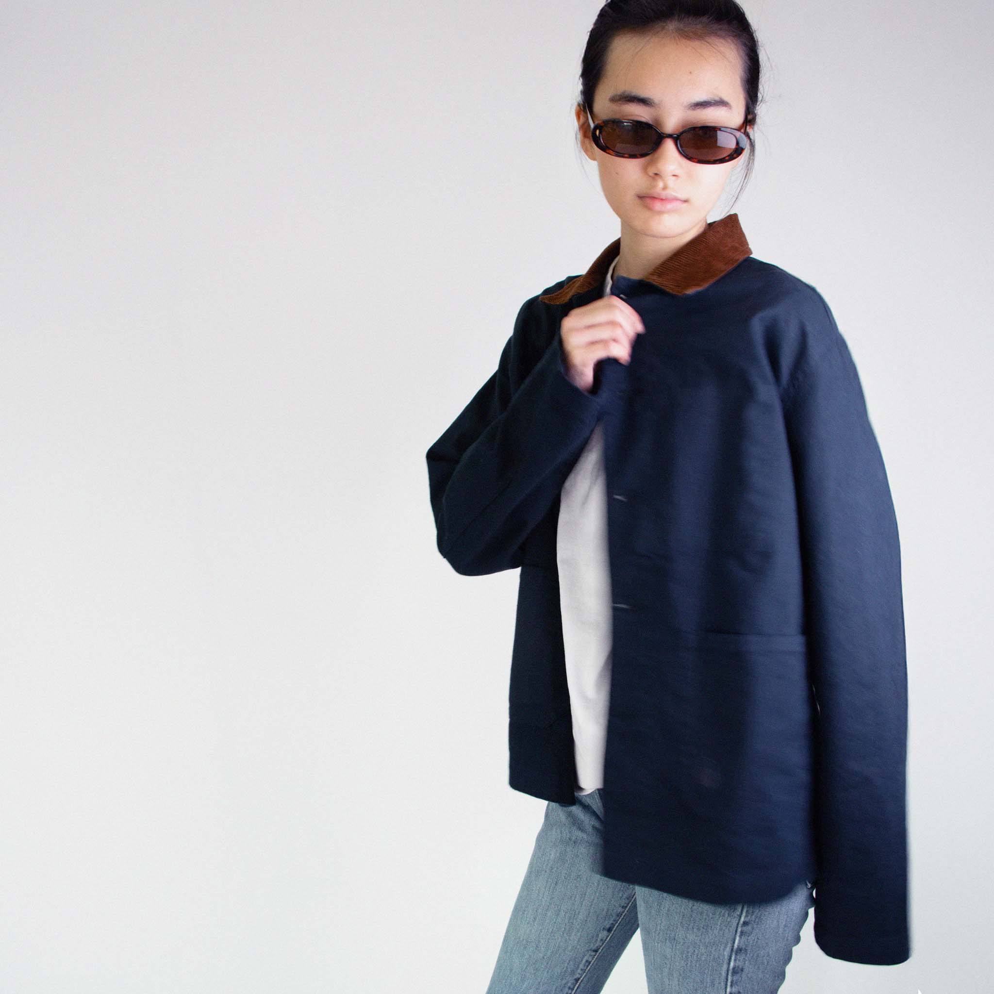 Model wearing the Nimes unisex chore blue jacket with a brown corduroy collar on a white background