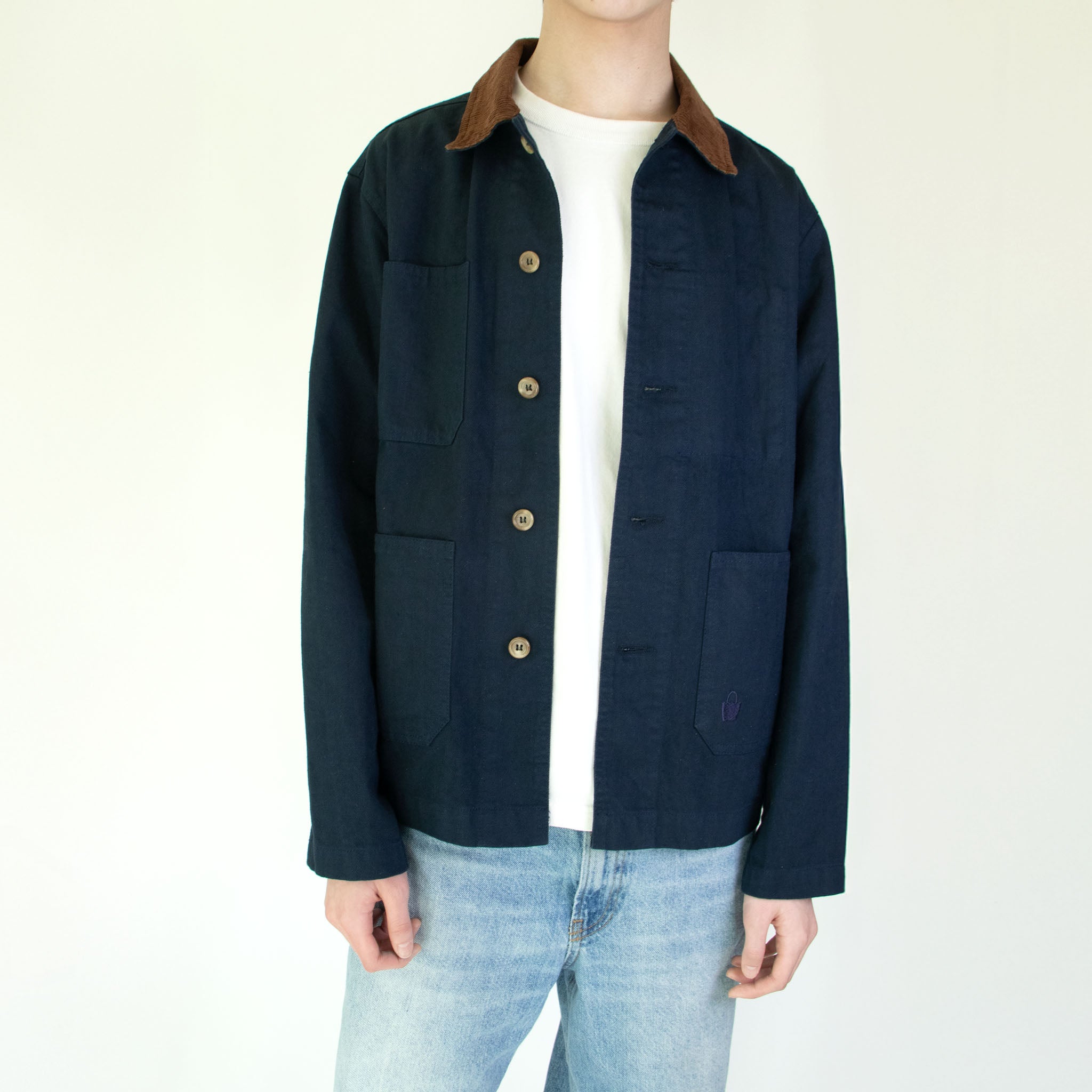 Model wearing the Nimes unisex chore blue jacket with a brown corduroy collar on a white background