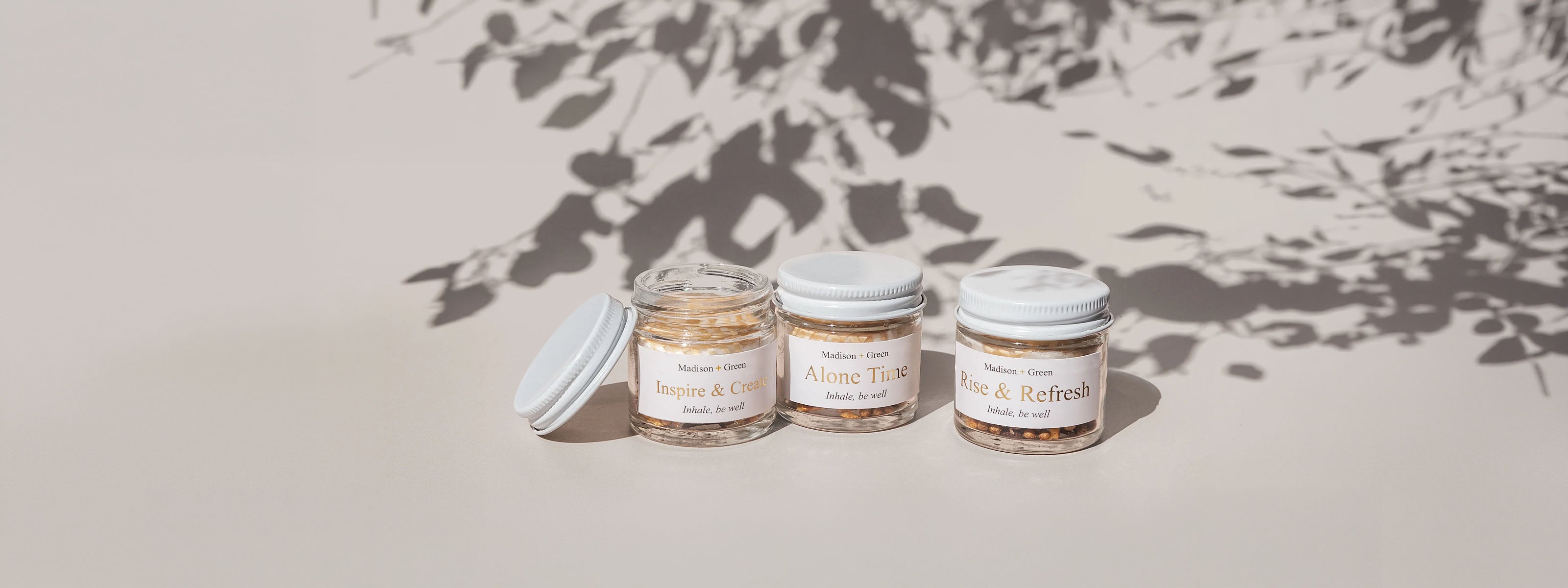 Three jars of aromatherapy inhalers on a light background