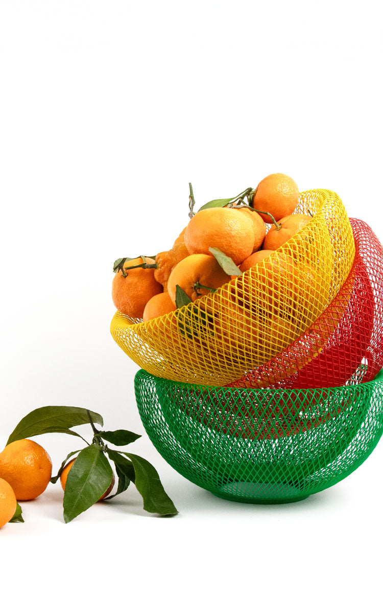 Image of all MoMA mesh wire bowls in yellow, red and green filled with tangerines