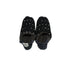 Pair of black slippers with white polka dots on a white background