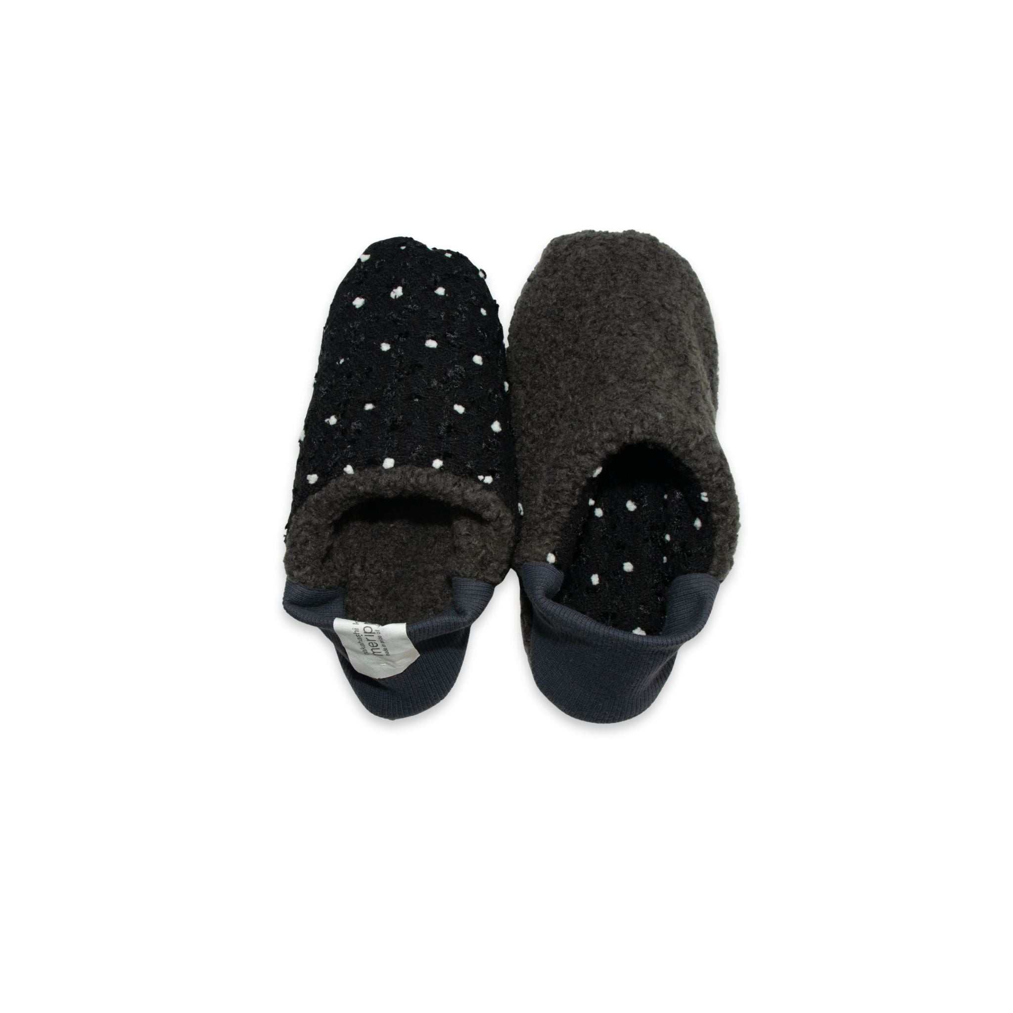 Pair of black slippers with white polka dots on a white background