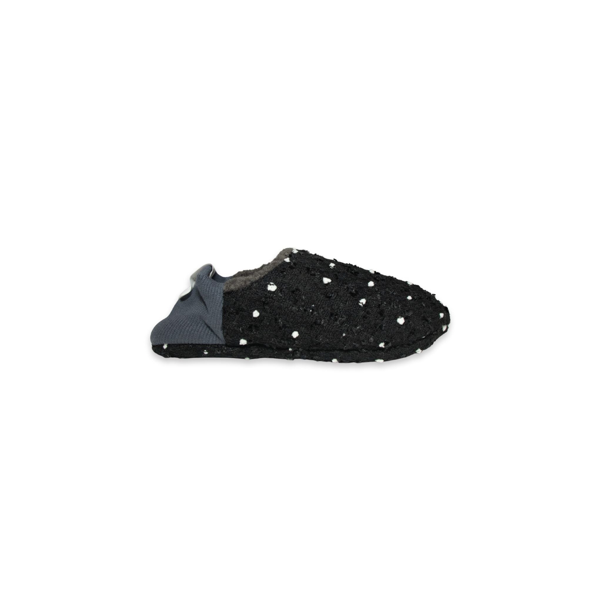 Side view of black slipper with white polka dots on a white background