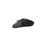 Angled view of black slipper with white polka dots on a white background