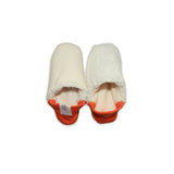A pair of creme colored  slippers with orange trim on a white background
