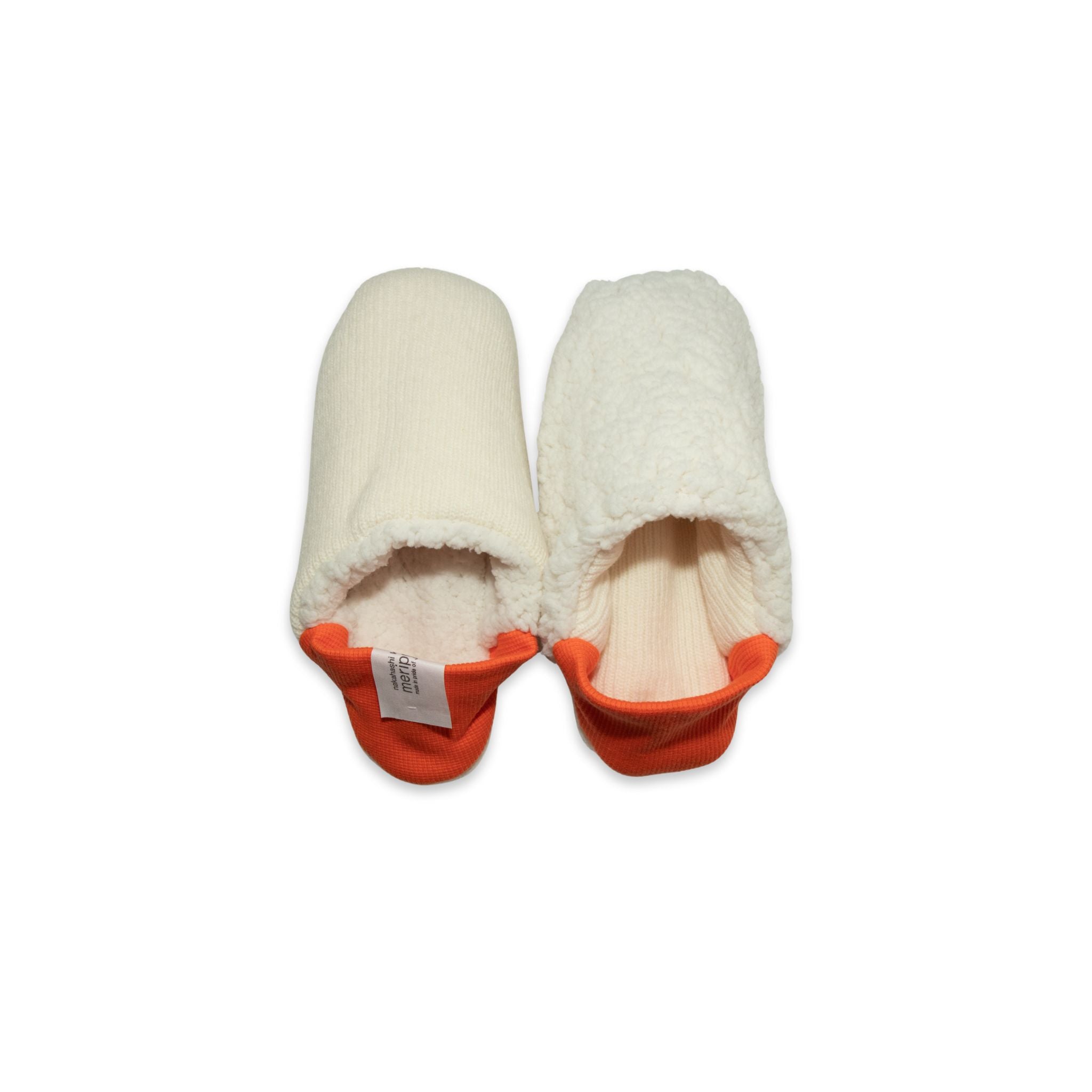 A pair of creme colored  slippers with orange trim on a white background
