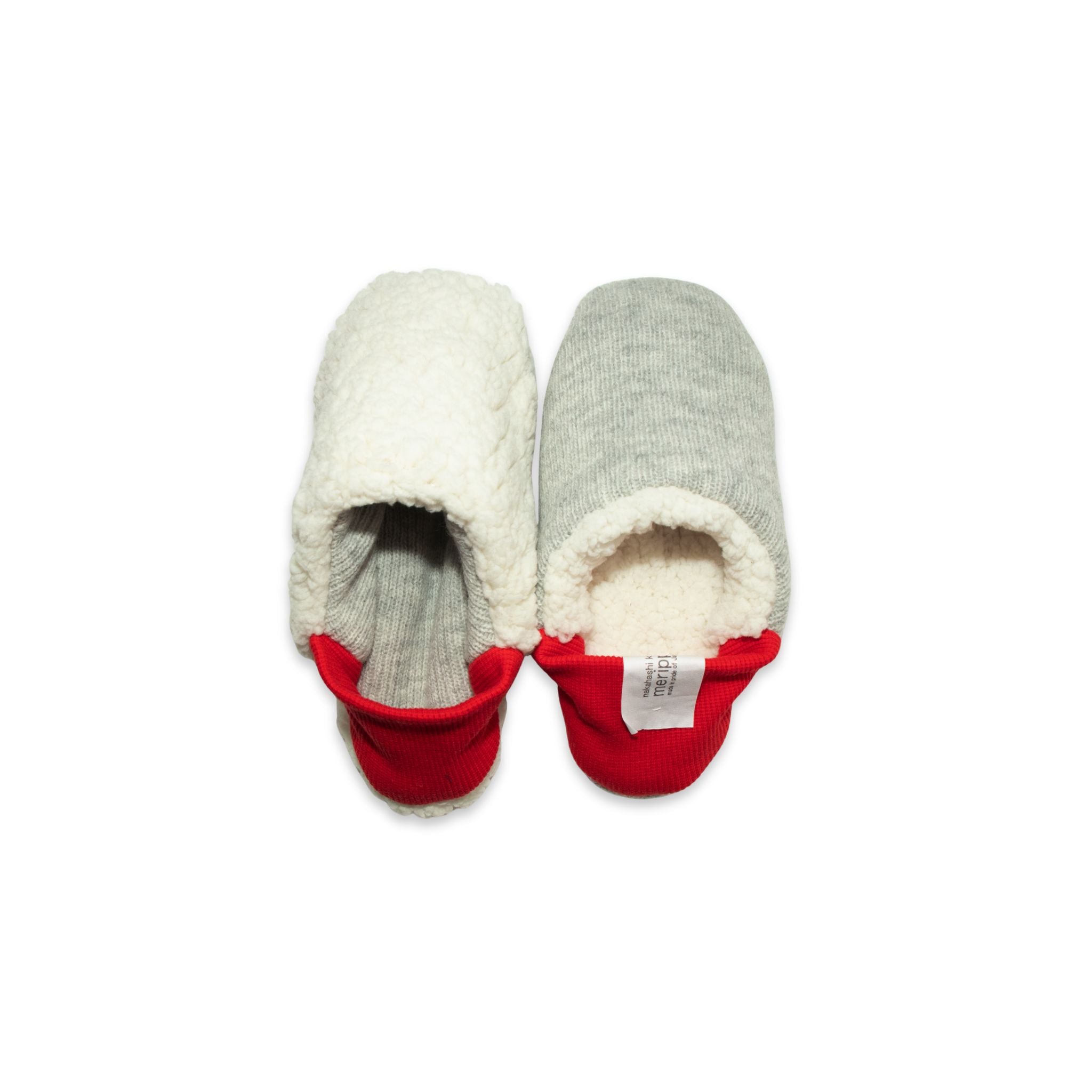A pair of grey colored  slippers with red trim on a white background