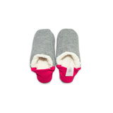 A pair of dark grey colored  slippers with pink trim on a white background
