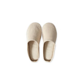 Pair of beige slippers on a white background