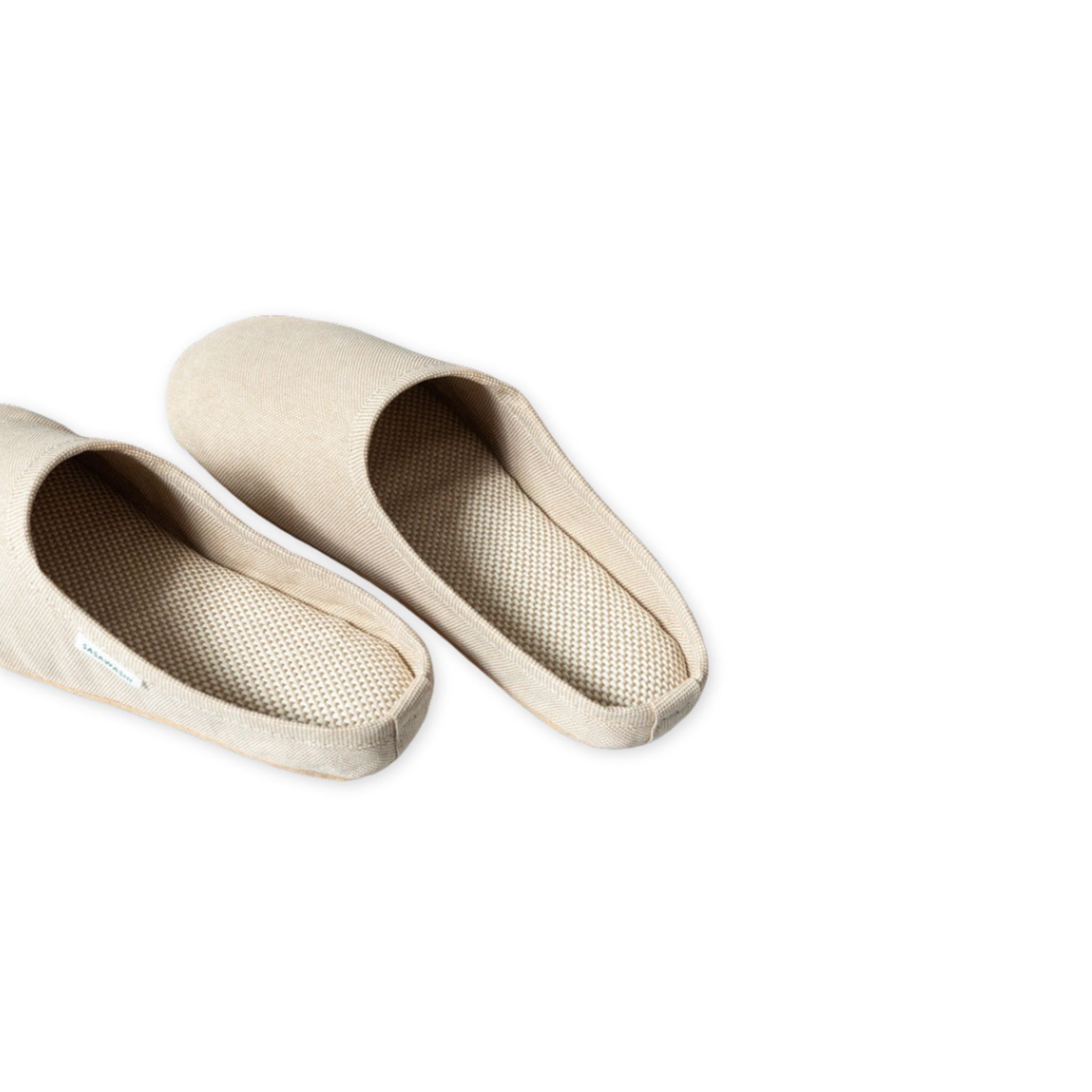Pair of beige slippers on a white background