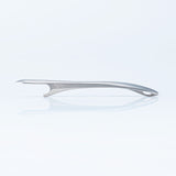 Side view of the Suwada brushed stainless steel bottle opener with a satin finish on a blue tinted background