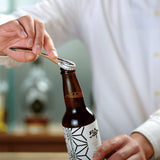 Person opening a beer bottle with the Suwada bottle opener