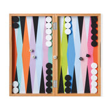 Top view of the colorful MoMA Backgammon set opened and all pieces in place ready to be played including the dice on a white background