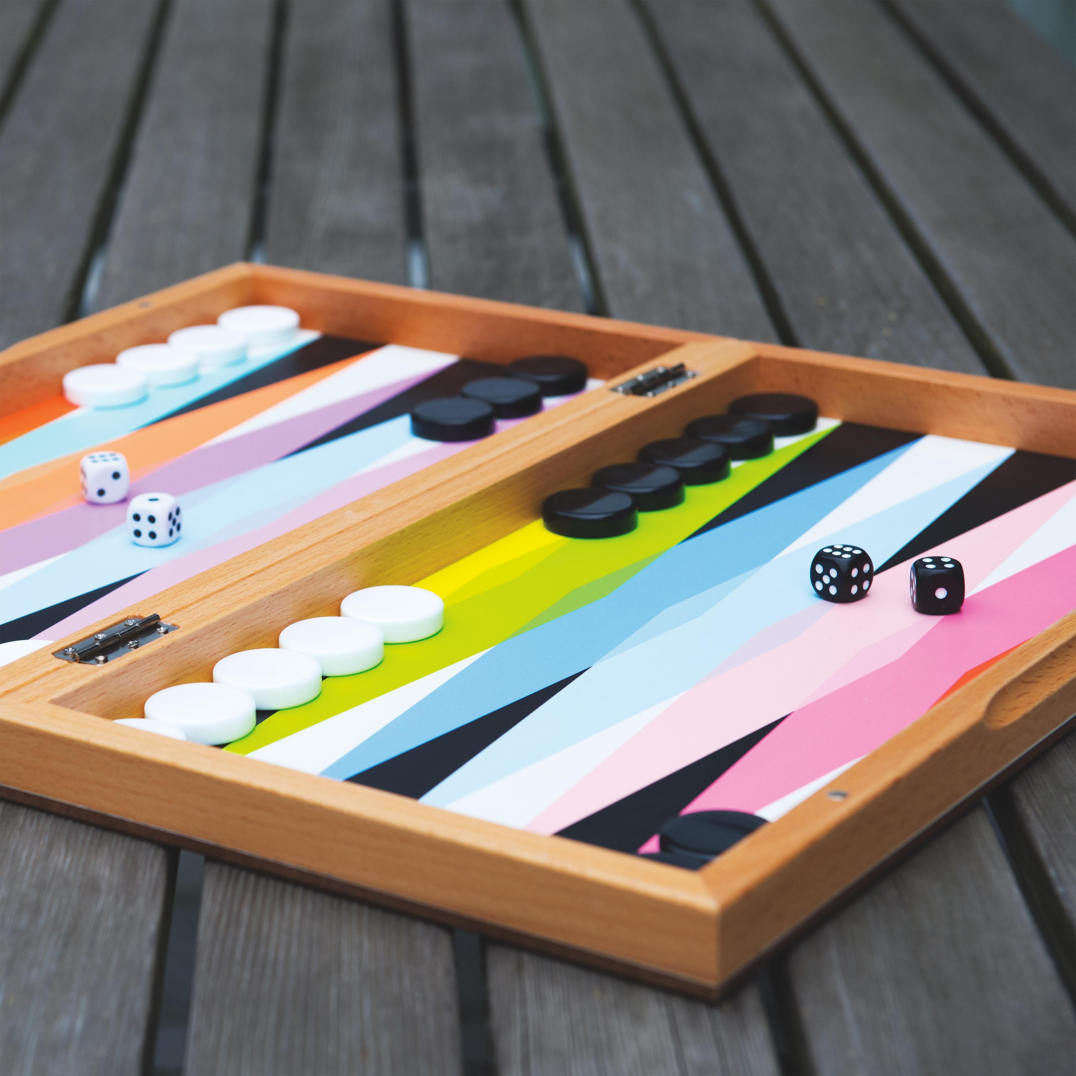 Lifestyle image of the colorful backgammon set by MoMA all set and ready to be played on a wooden table