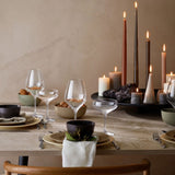 Dining table set with candles and glasses in a warm setting