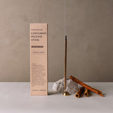 Cinnamon incense stick with packaging and cinnamon sticks on a neutral background