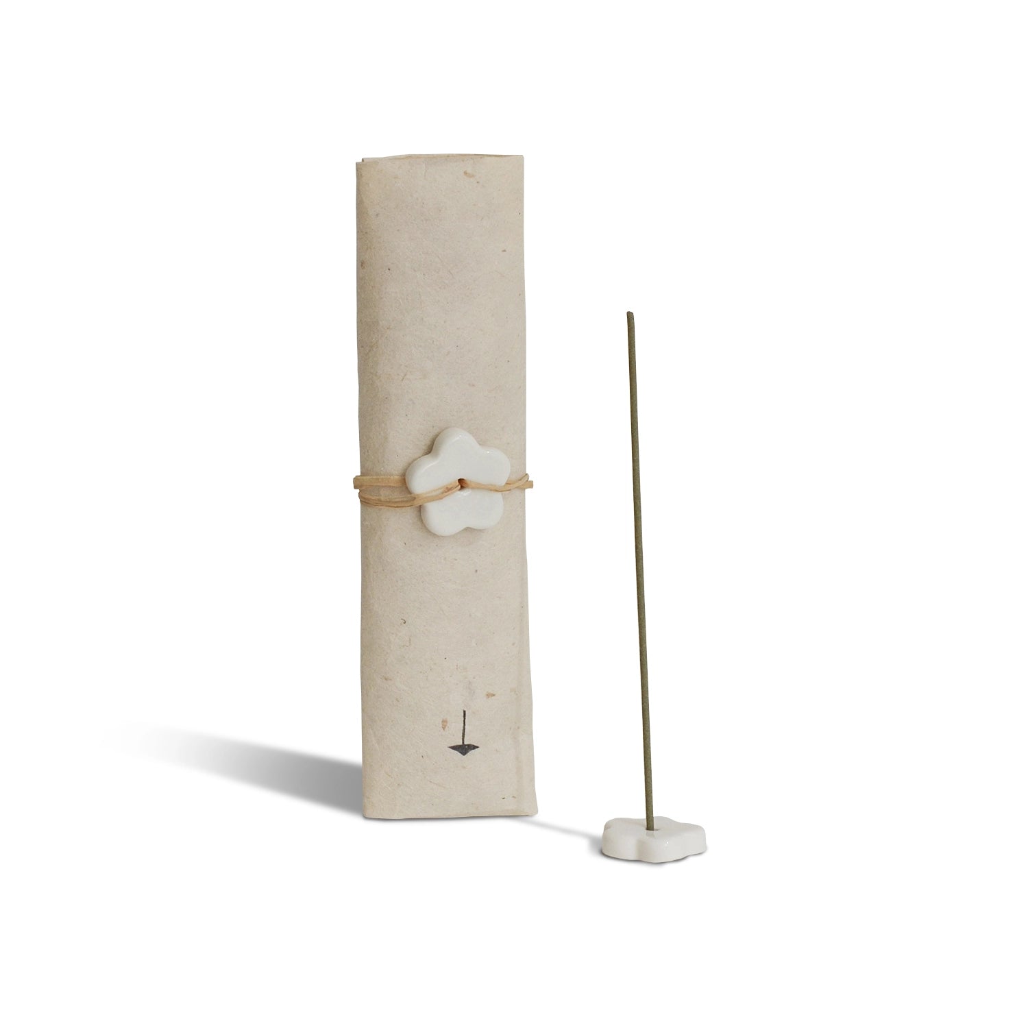 Incense stick holder with a cylindrical beige container and a white flower-shaped weight on a white background
