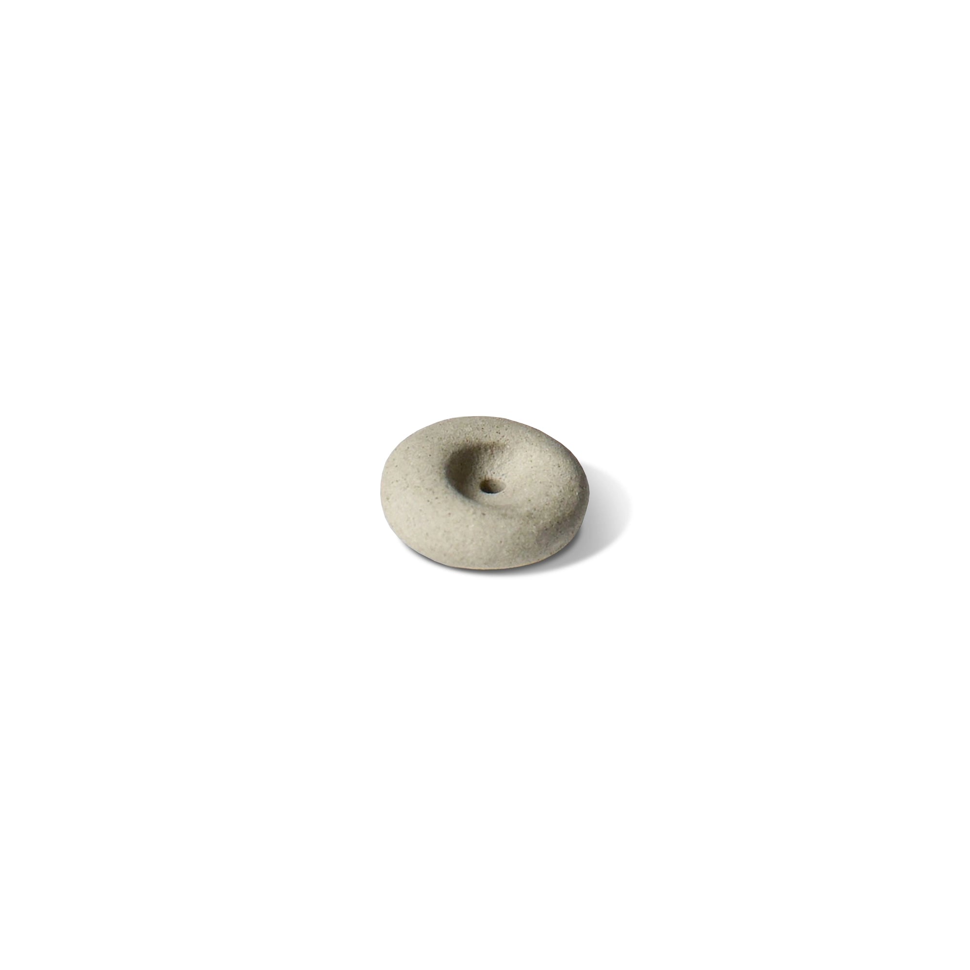 A mini light grey ceramic pebble incense holder on a white background