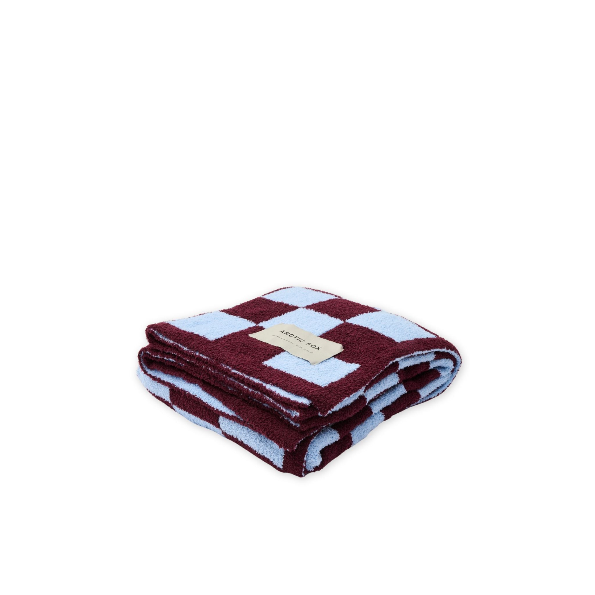 Folded checkered blanket with a brand label on a white background