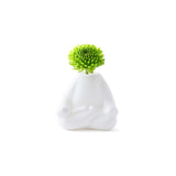 White ceramic vase with a green flower on a white background