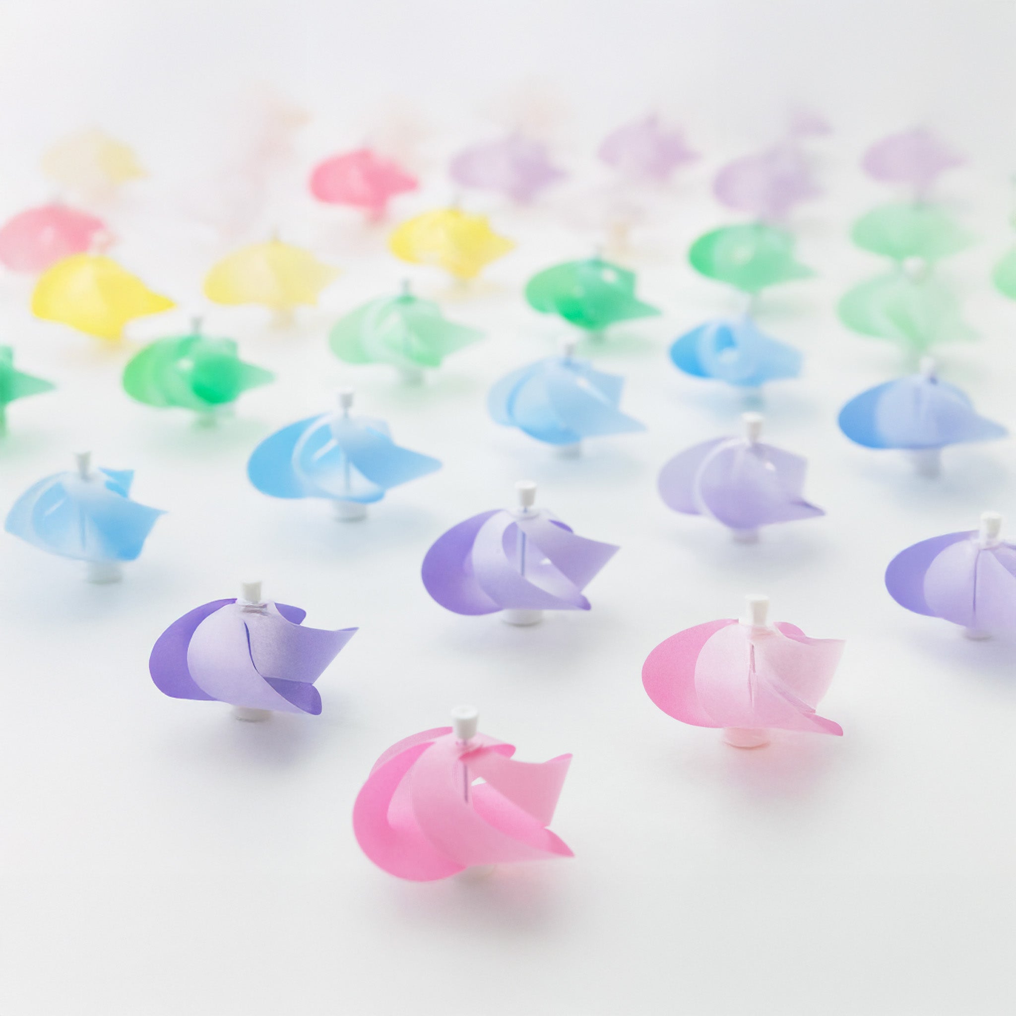 A collection of colorful magnetic pinwheels - Kaze Guru Ma - on a white background