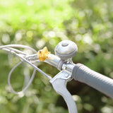 A gold colored magnetic pinwheel on a bicycle handle