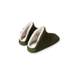 Pair of green slippers with white furry lining on a white background