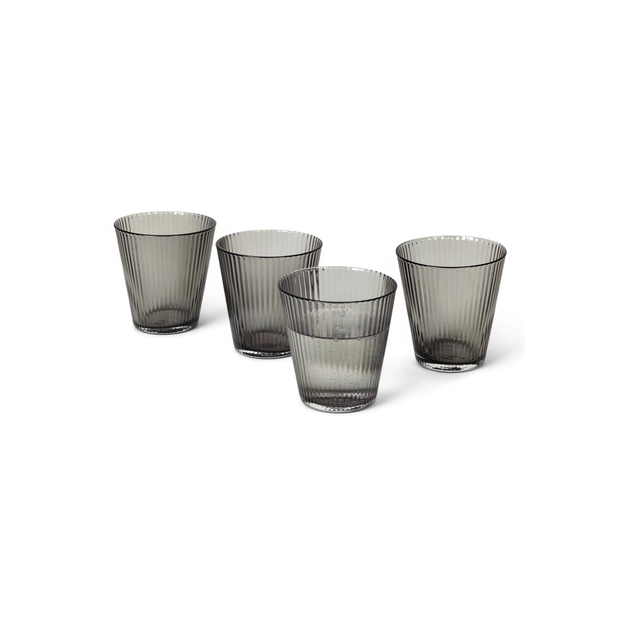 Four smoked gray glass tumblers on a white background