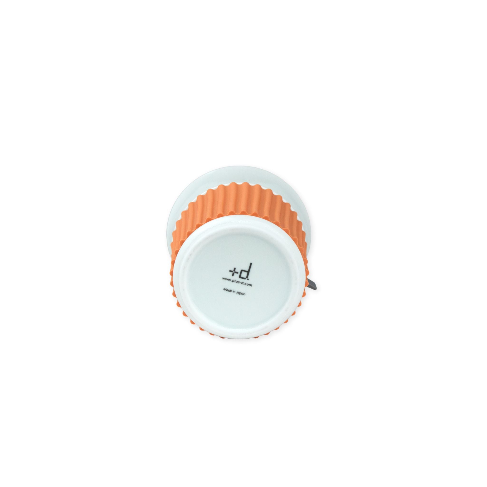 The bottom of a white mug with an orange ribbed pattern showing the brand label on a white background