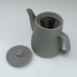 Gray teapot with a mesh filter on a white background