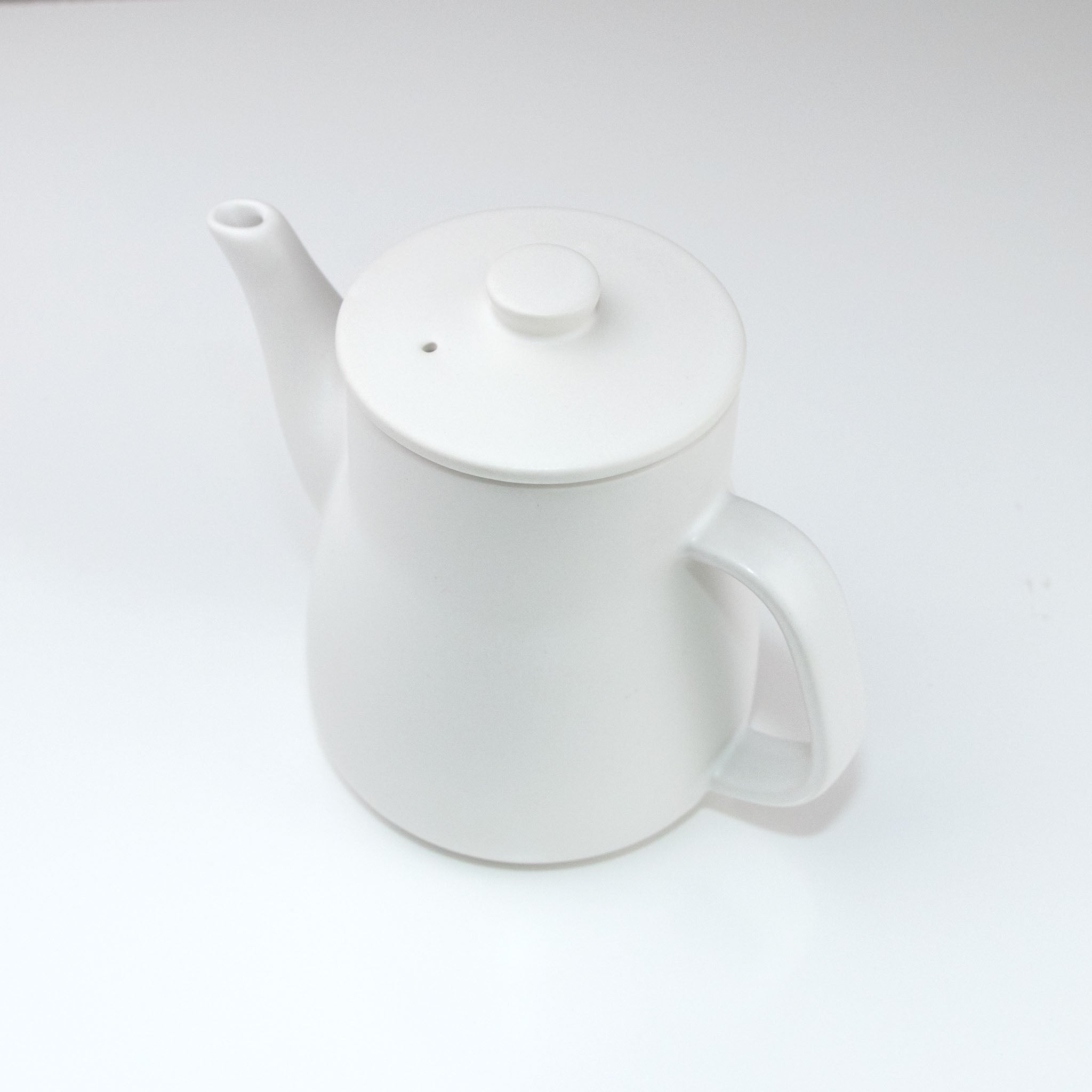 White ceramic teapot on a white background
