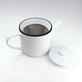 White teapot with a black rim on a white background