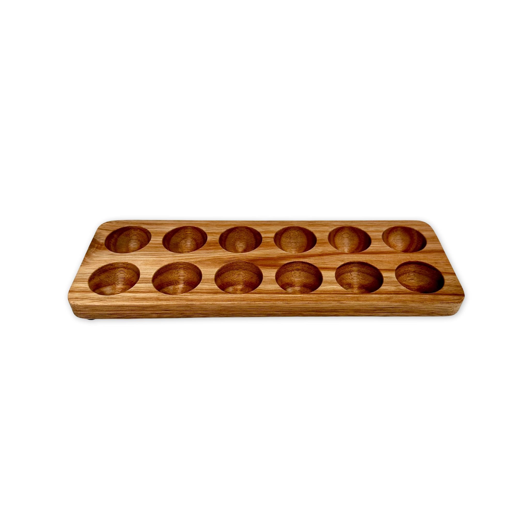 Handcrafted acacia wood egg holder with twelve round slots, shown on a white background.