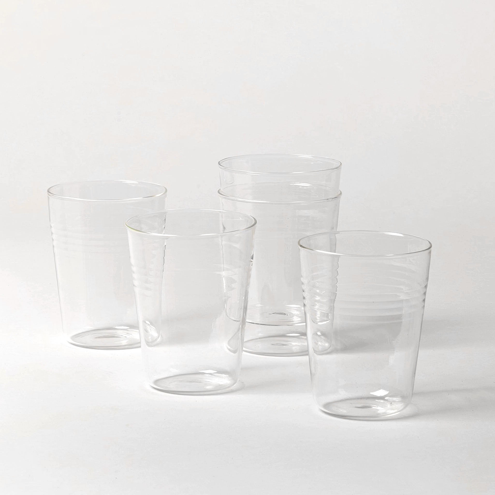 Set of clear glass tumblers on a white background